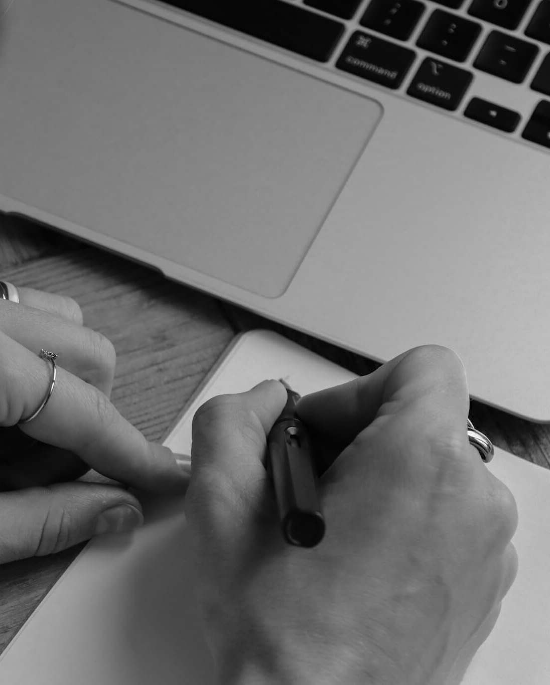 Person schreibt Notizen am Laptop für die Content-Planung.