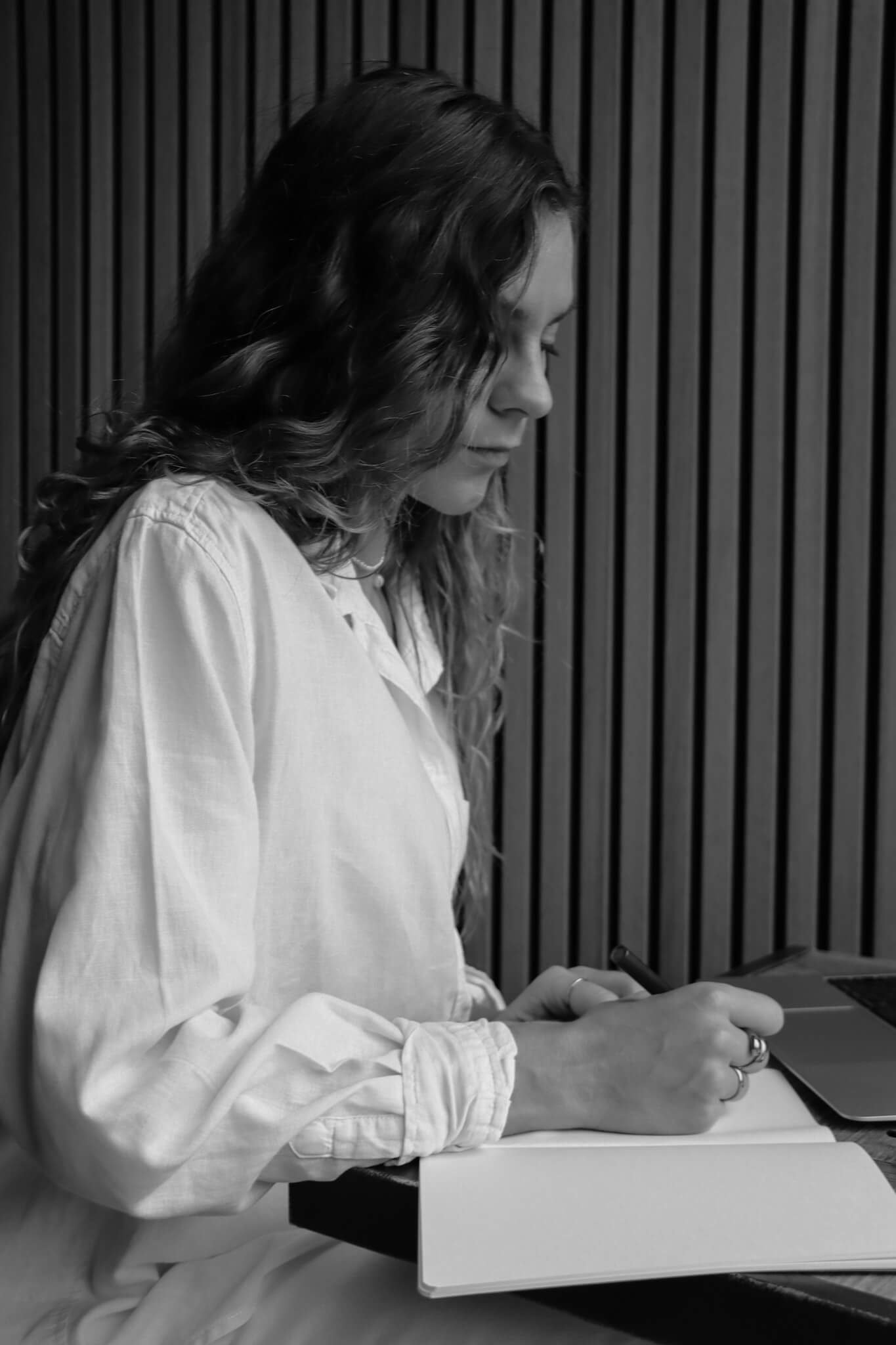 Frau schreibt Notizen am Laptop für SEO-Copywriting
